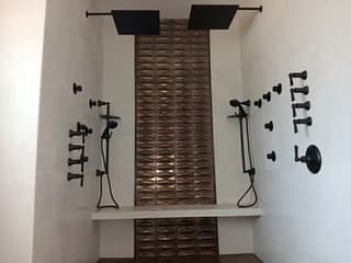 Completed tiled shower with two sets of black shower fixtures