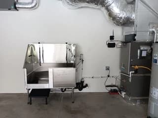 Stainless steel wash station with connected plumbing in a utility space