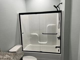 Finished shower with glass enclosure and black trim